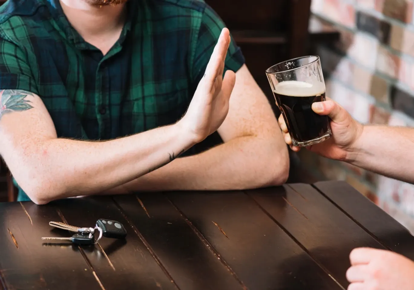 Wszywka alkoholowa Esperal / Disulfiram Wrocław: dłoń odmawiająca kufla piwa przy stole